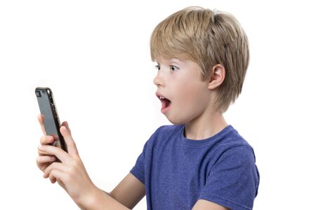 Portrait of a surprise young boy looking at smartphone, on white backgroundの写真素材