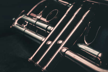 Close up of the valves of a trumpet on a black background. Details of a trumpet