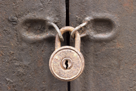 Closeup vintage old metal door in grungy style with with old rusted padlock.の写真素材
