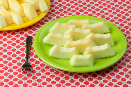 Freshly cut melon on checkered tablecloth.