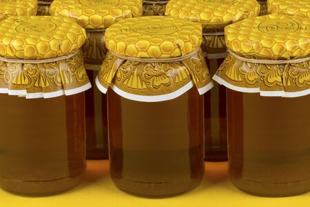 Composition with jars of honey on yellow background.の写真素材