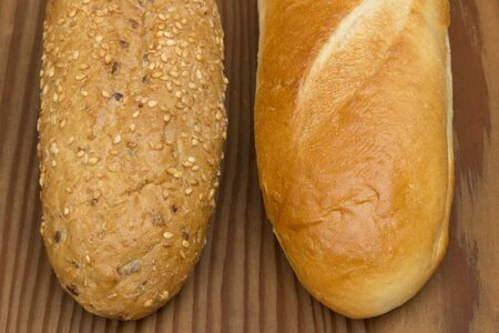 Two types of baguettes on wooden background.の写真素材