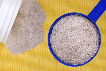 A close up of a chocolate whey isolate protein,viewed from above on a tablecloth.