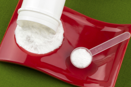 Glutamine and creatine monohydrate on a green background.の写真素材