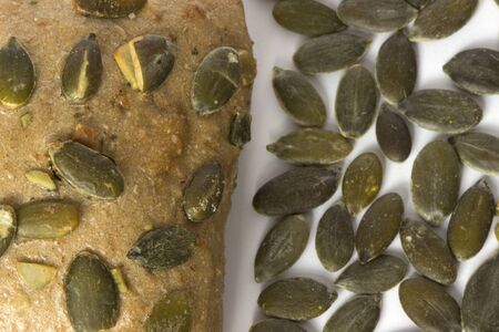 One small bread with pumpkin seeds close up on white background.の写真素材