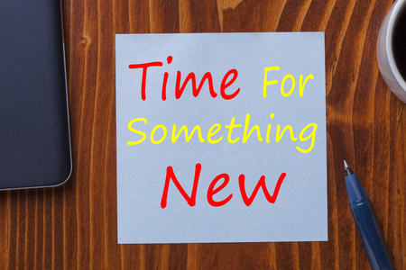 Time For Something New written in note with pen, smartphone and cup of coffee on wooden desk top view.の写真素材