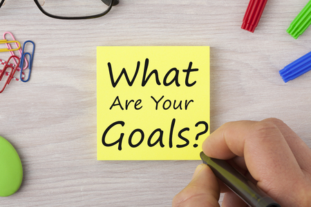 Hand writing What Are Your Goals in note with marker pen and glasses.Top view.の写真素材