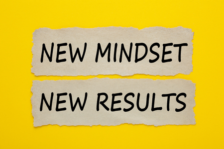 NEW MINDSET, NEW RESULTS written on old torn paper on yellow background. Business Concept. Top view.