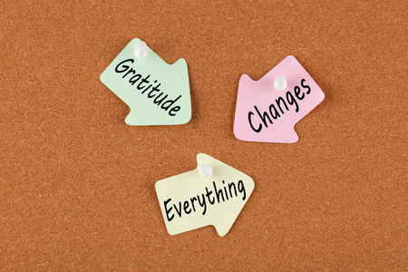 Gratitude Changes Everything written on color reminder notes with pin on cork board. Business concept.の写真素材