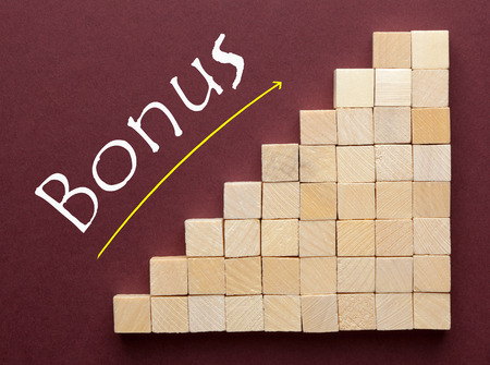 Word Bonus on ascending arrow above wooden cubes.  Business Concept.の写真素材