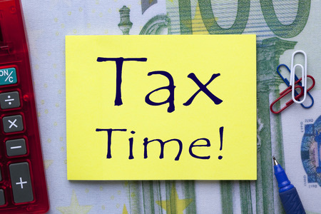 Tax Time written on note with pen a side and office supplies. Business conceptの写真素材
