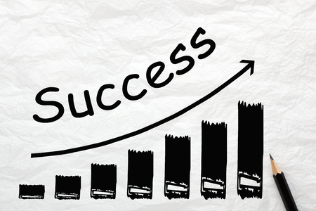 Word Success on ascending arrow written on wrinkled lined paper. Diagram in the shape of a staircase, business concept.の写真素材