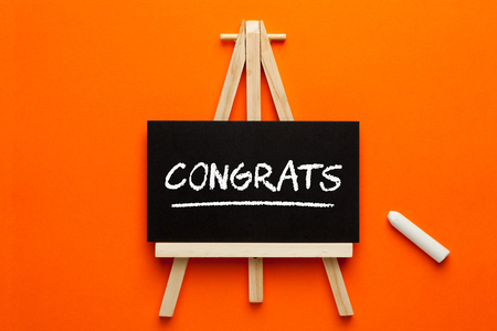 Congrats written on blackboard on tripod with chalk. Business Concept.の写真素材