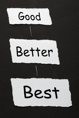 "Good Better Best'' text on 3 piece of torn paper over black surface.の写真素材
