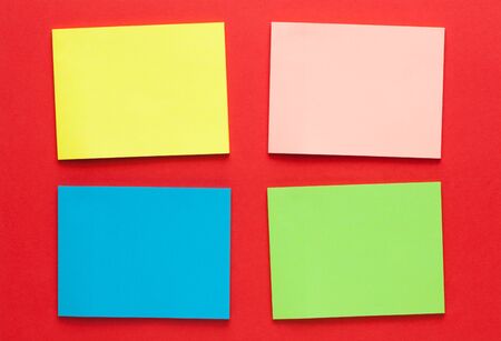 Set of blank colored notes on red background. Space for text.