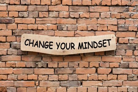 Change Your Mindset phrase on wooden sign on brick wall background. Business concept.の写真素材
