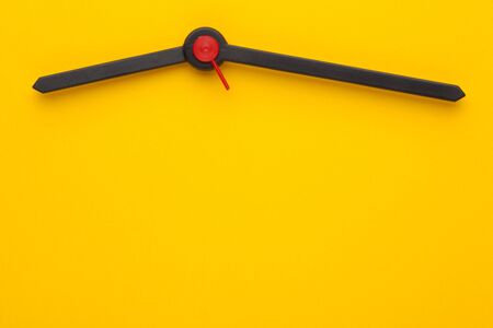 Hour hand, minute hand and a red second on yellow dial of the clock. Copy space for text.の写真素材