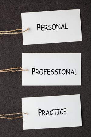 The words Personal, Professional and Practice written on paper labels set on black background. Business conceptの写真素材