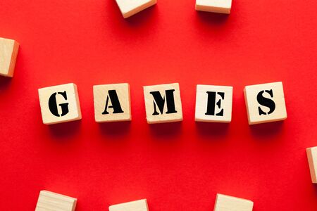 The word Games written on cubes shape wooden blocks on red background.の写真素材