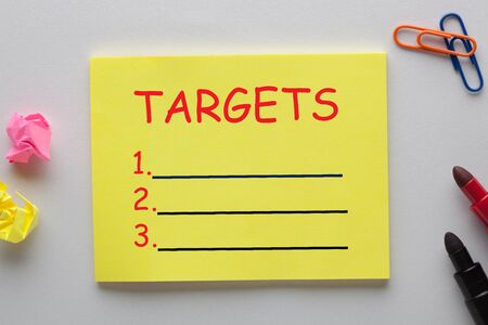 Targets blank list on note with marker pen and various stationery. Business concept.