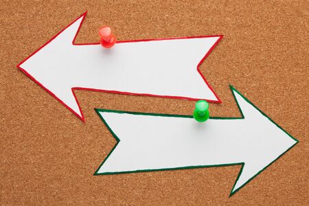 Blank opposite arrows pinned on cork board. Business conceptの写真素材