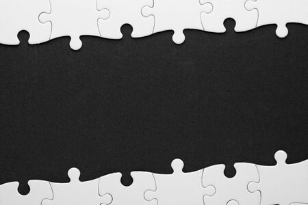 Blank puzzle pieces over black surface. Copy space for text.の写真素材