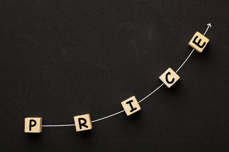 The word Price with directional arrow written on cubes shape wooden blocks on black background.の写真素材