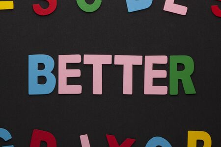 The word Better made of colorful alphabet letters on black background.の写真素材