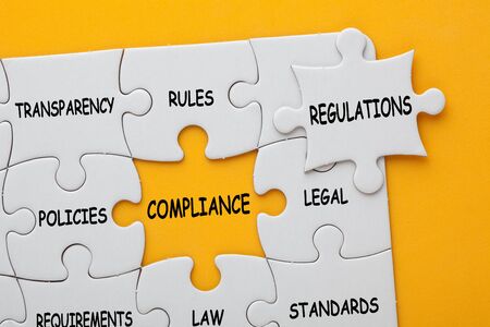Missing jigsaw puzzle piece with text regulations, covering text project and different business words which matches a yellow space marked compliance.の写真素材