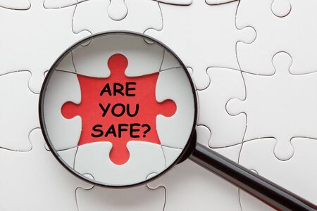 Are You Safe text with magnifying glass over jigsaw puzzle.の写真素材