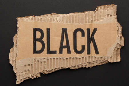 The word black on torn paper on blackの写真素材