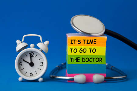 It's time to go to the doctor text on note with stethoscope and bells clock.の写真素材