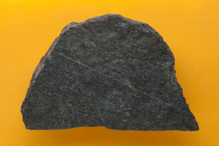 Dark grey gneiss on yellow background.