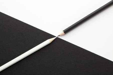Black and white pencils facing each other.の写真素材