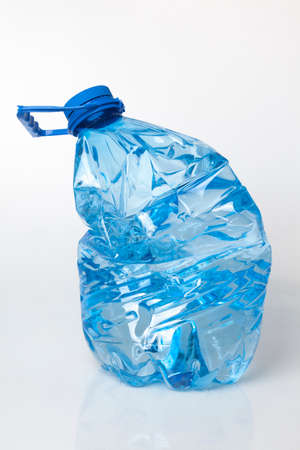 Crushed plastic 10 l bottle with water on white background