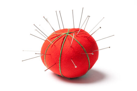 Red pillow with pins isolated on white background.の写真素材