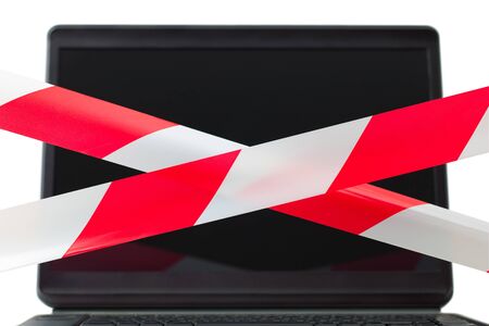 Two red and white barrier tapes are crossed in front of a computer display. The composition symbolized limitation of use of the computer Internet chat. Also warning about dangerous content and influence.の写真素材