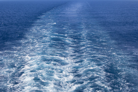 Image of a wake in the sea, caused by big ship propellers during movement.