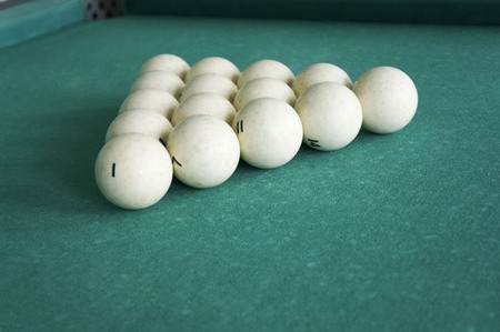 Russian billiards - large white balls with an orange cue and a wooden cue on a large table with...