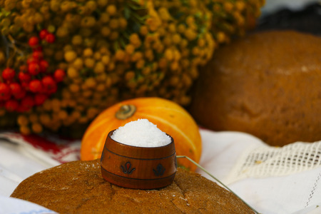 Autumn still life - loaf, pumpkin, mountain ash, tansy, wheat ears, salt,
on a white tablecloth with laceの写真素材