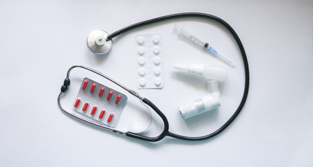 Stethoscope, syringe, inhaler, spray and pills isolated on white backgroundの写真素材