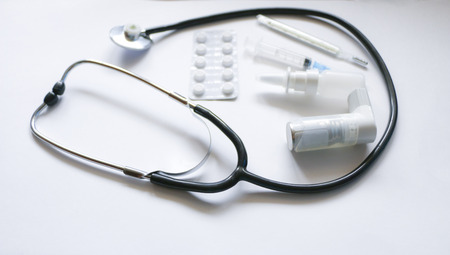 Stethoscope, syringe, inhaler, spray and pills isolated on white backgroundの写真素材