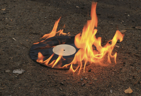 vinyl record burns bright orange flame on the asphalt