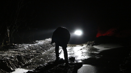 Frozen forest road at night with the lights from the car - off-road with frozen mud, ice, rut and puddles
の写真素材