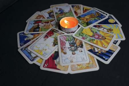 YOSHKAR-OLA, RUSSIA - NOVEMBER 13, 2017: Fortune telling on Tarot cards on a black background with a burning candleのeditorial素材