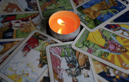 YOSHKAR-OLA, RUSSIA - NOVEMBER 13, 2017: Fortune telling on Tarot cards on a black background with a burning candleのeditorial素材