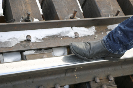 men's legs in jeans and boots are  railway. Walk on  rails. Concept: loneliness, travel,  road of life,  dangerous path.の写真素材