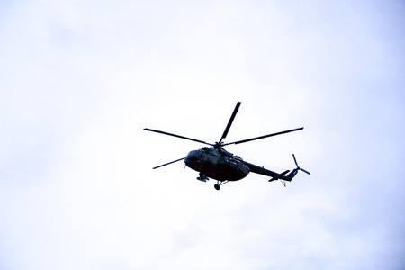 large military helicopter hovers in  sky. A camouflaged helicopter flies at high speed.の写真素材