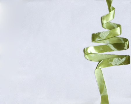 Christmas tree from ribbons. Green glitter ribbon in shape of Christmas tree on white background. Green glitter ribbon in shape of Christmas tree on white background. Copyspace for text, congratulations, invitation.の写真素材