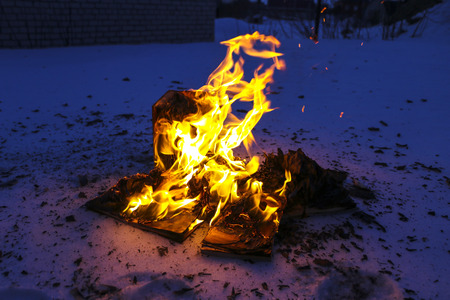 burning book in the snow. pages with the text in the open book burn with a bright flame.